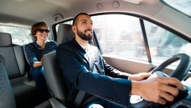 Conducteur souriant parlant avec une femme d'affaires élégante.