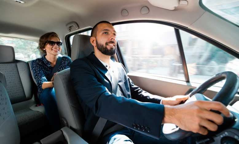 Conducteur souriant parlant avec une femme d'affaires élégante.