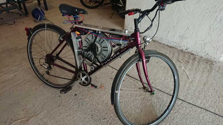 Il transforme une très vielle bicyclette en vélo électrique avec un moteur de machine à laver...