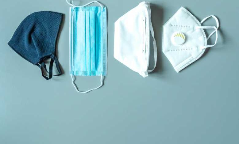 Différents masques de protection sur fond bleu avec espace de copie. Masque de tissu réutilisable, masque médical jetable, masque à facemask avec soupape respiratoire. Le choix de la protection. Protection antivirus