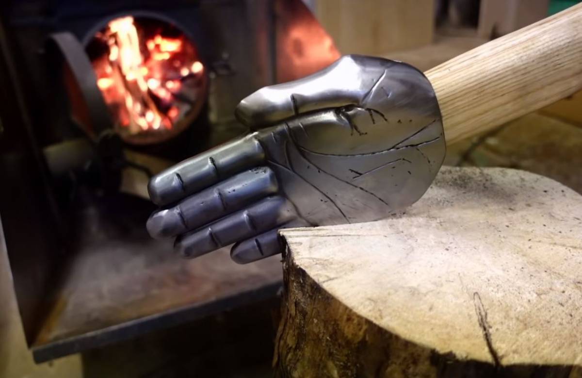 Il fabrique une hache en forme de main pour "casser" les buches à la manière d'un karatéka !