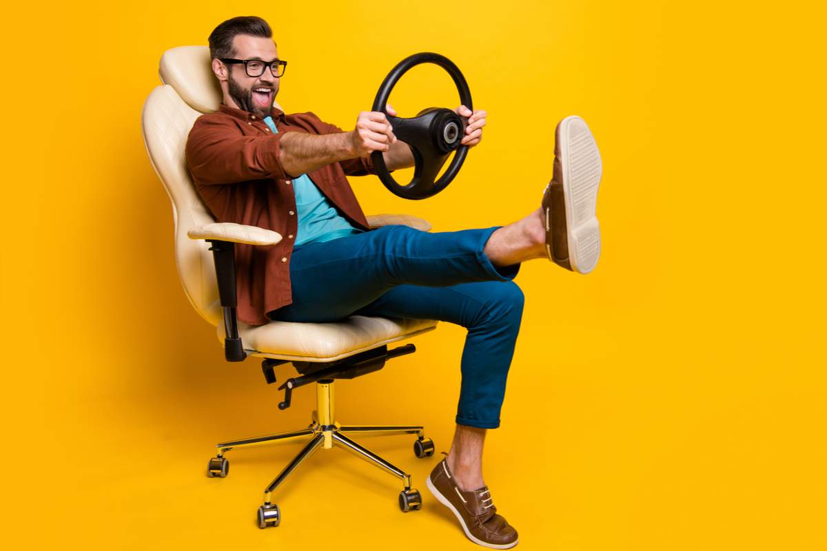 Un homme sur un fauteuil jaune avec un volant à la main