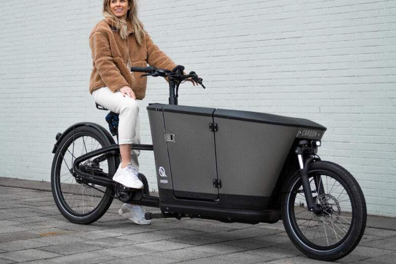 Un vélo cargo avec ceinture de sécurité et des protections latérales.