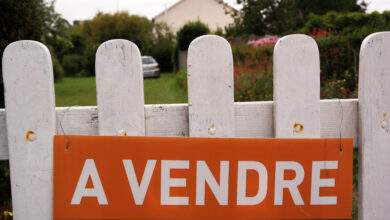 Une maison avec un panneau à vendre