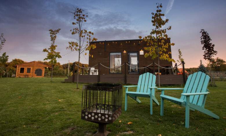 heminée et chaises turquoise devant une minuscule maison sur roues