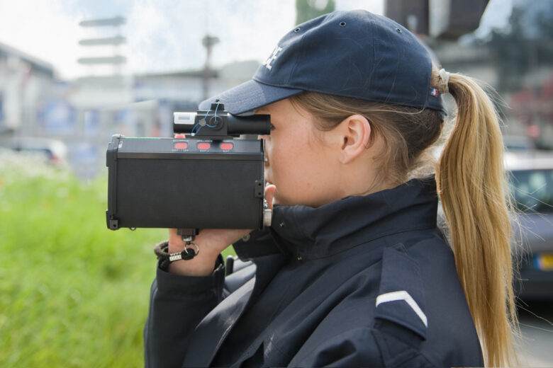 PARIS - 20 MAI 2014 - Une femme de police française contrôle la vitesse d'une voiture avec un radar mobile