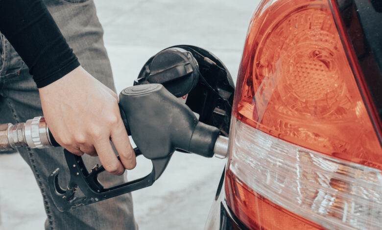 Gros plan sur une main d'homme tenant une pompe à essence