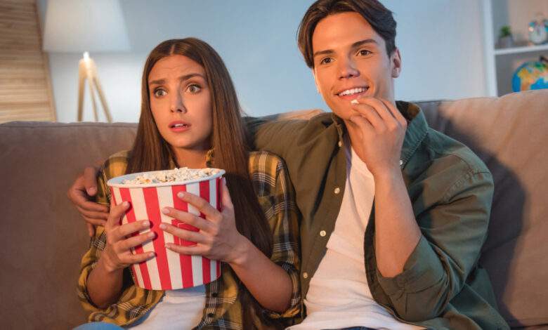 Regarder un film effrayant en mangeant du pop-corn à la maison.