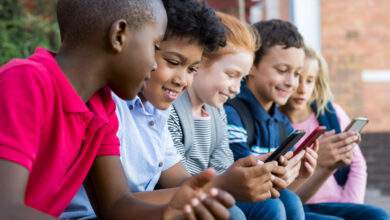 Élèves utilisant un téléphone portable à l'école primaire