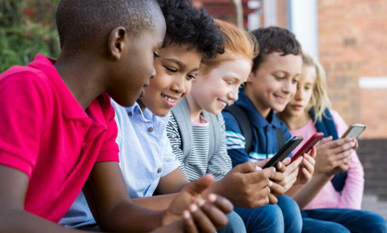 Élèves utilisant un téléphone portable à l'école primaire