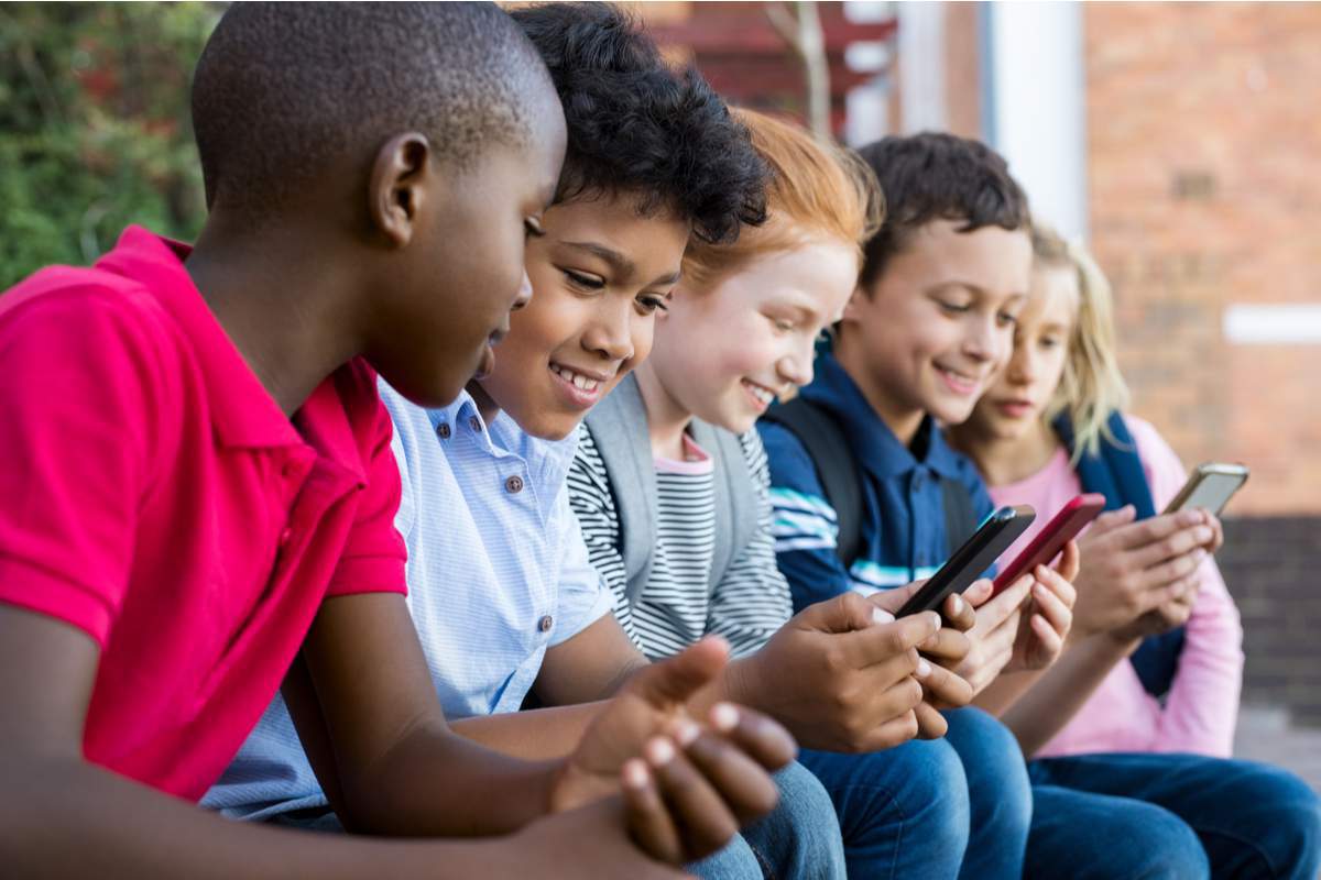 Élèves utilisant un téléphone portable à l'école primaire