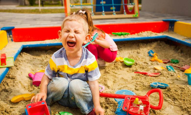 deux enfants sales jouant dans le bac à sable