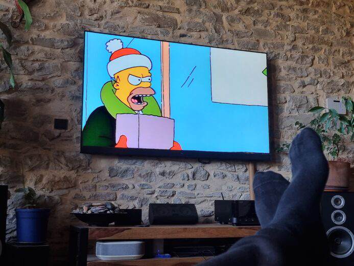 Un homme qui regarde les Simpson à la TV