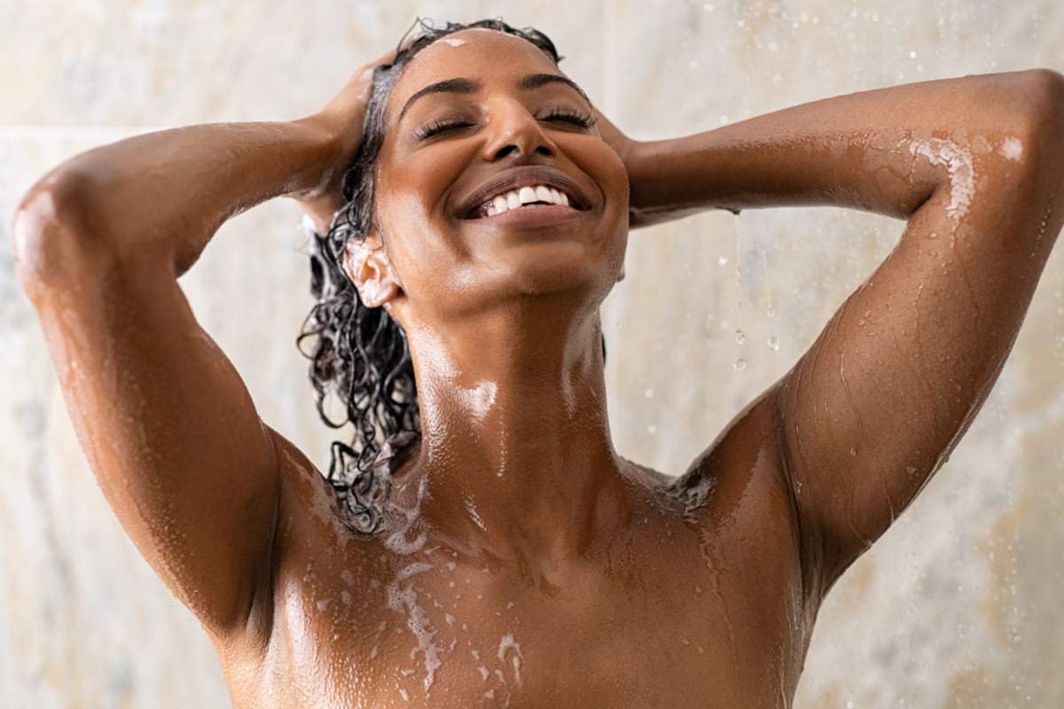 Jeune femme se lavant les cheveux dans la douche