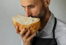 Un boulanger tient un pain frais rond dans les mains