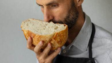 Un boulanger tient un pain frais rond dans les mains