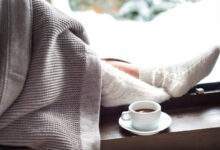 Pieds féminins dans des chaussettes chaudes en laine d'hiver et recouvertes d'une couverture