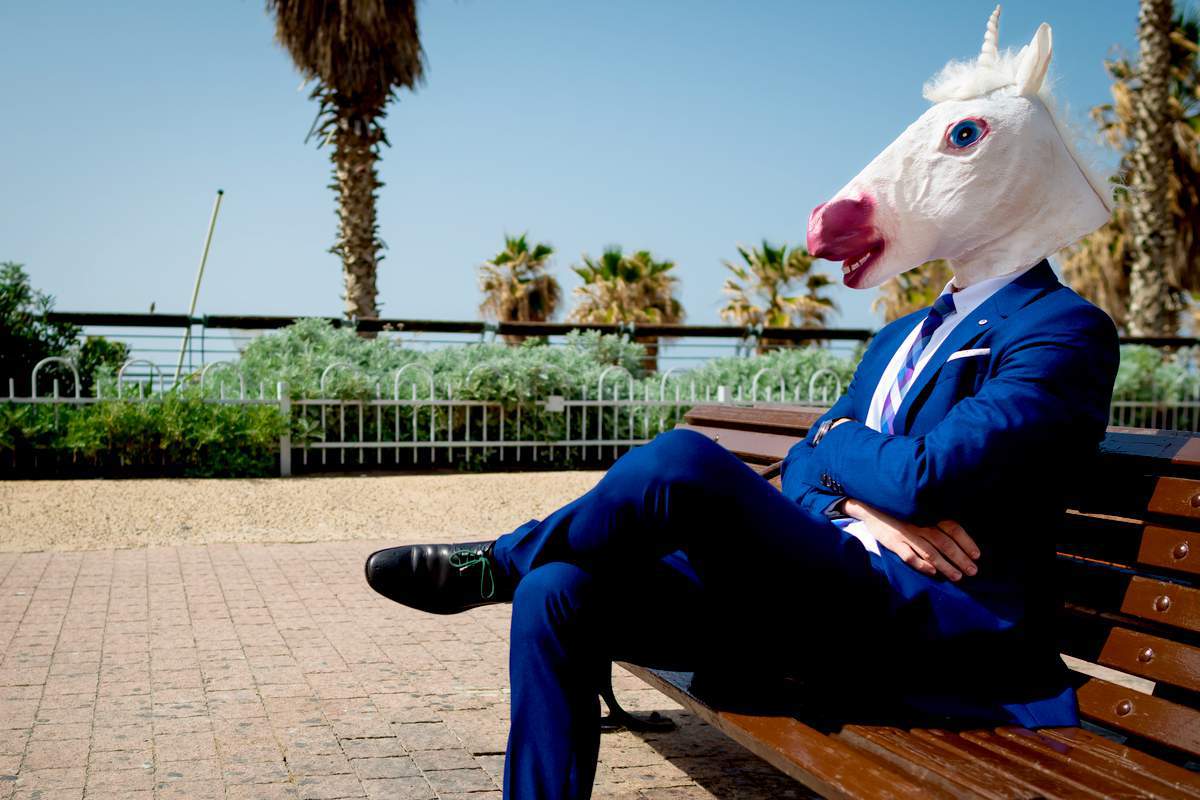 Un homme en costume avec un masque de licorne