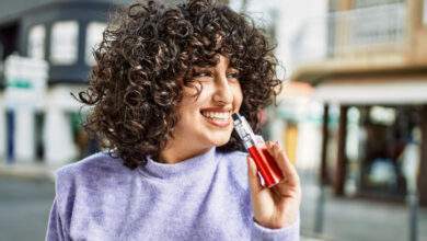 Jeune femme tenant une cigarette électronique