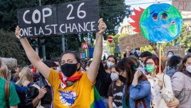 des jeunes affichent des pancartes lors de la marche qui a eu lieu lors de l'événement pré-COP