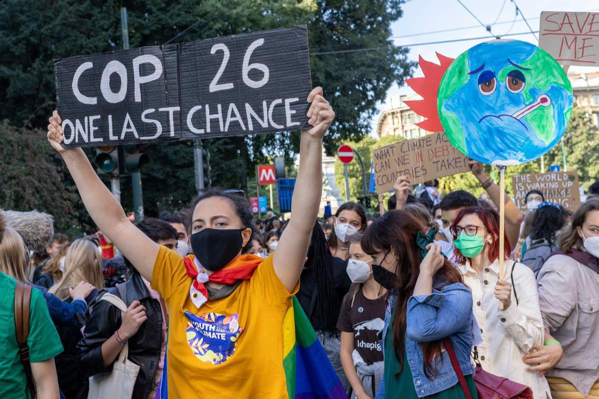 des jeunes affichent des pancartes lors de la marche qui a eu lieu lors de l'événement pré-COP