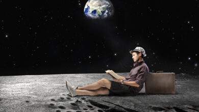 Jeune homme assis sur la Lune et lisant un livre