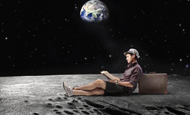 Jeune homme assis sur la Lune et lisant un livre