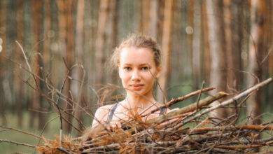 une adolescente ramasse des branches de bois de chauffage