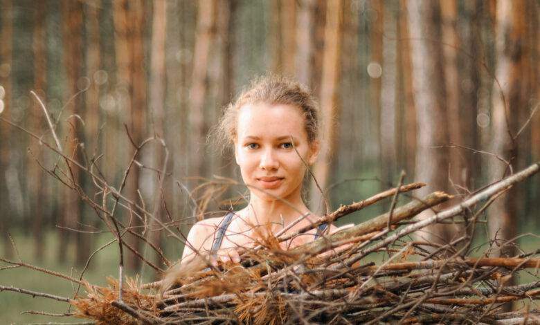 une adolescente ramasse des branches de bois de chauffage