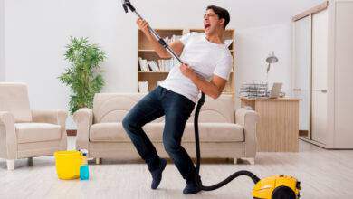 Homme nettoyant sa maison avec aspirateur