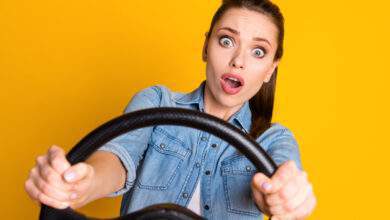 Une femme au volant sur fond jaune