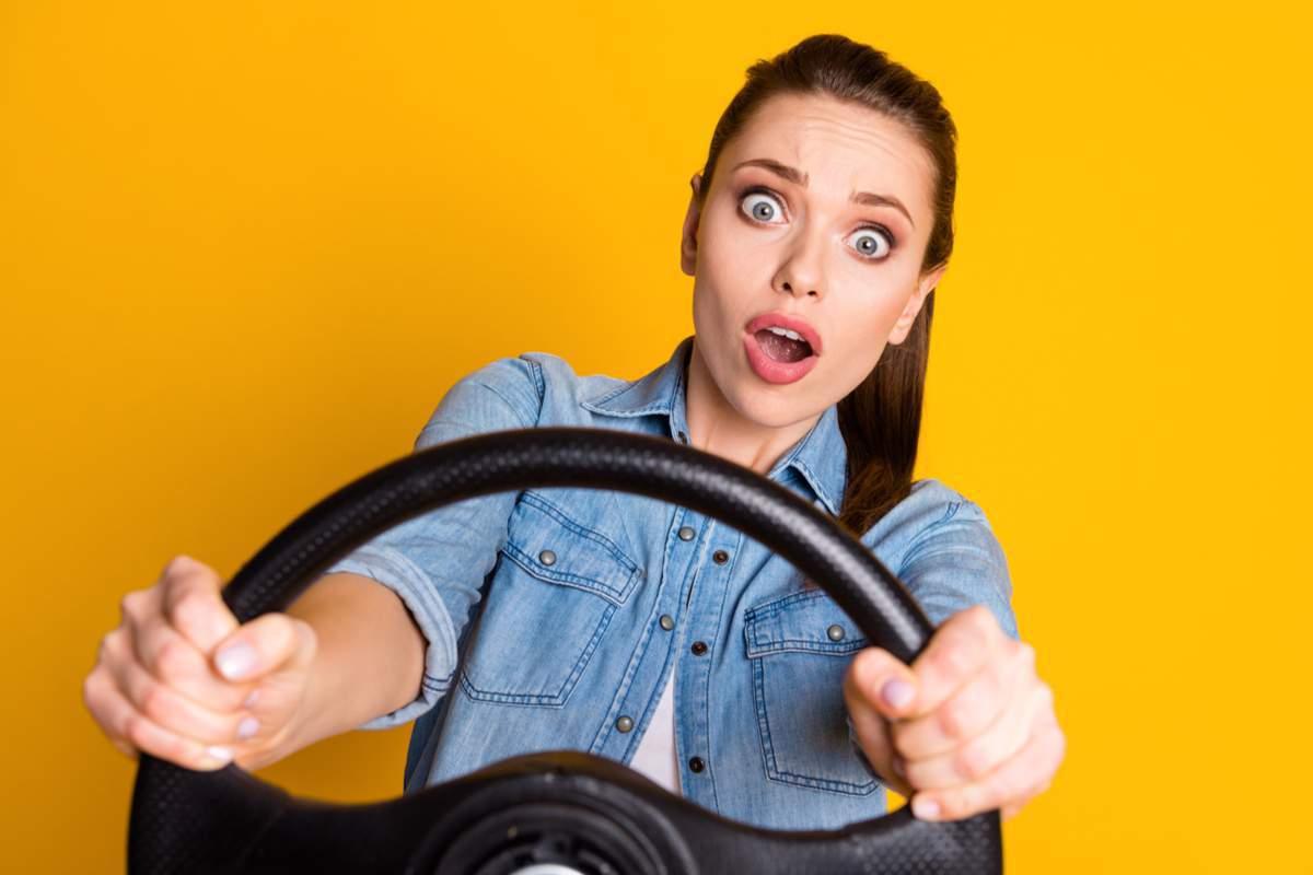 Une femme au volant sur fond jaune