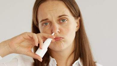 femme avec un spray nasal dans le nez