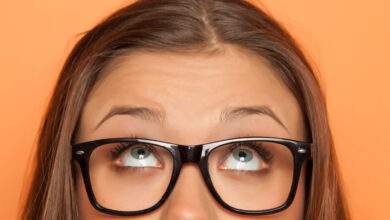 demi-portrait d'une jeune fille avec lunettes levant les yeux