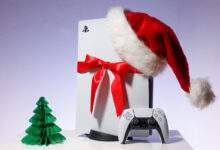 console de jeu Sony PlayStation 5 sur fond bleu blanc. Édition cadeau de Noël avec bonnet de Noel et ruban rouge