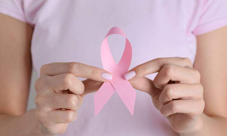 Femme avec un ruban rose, en gros plan. Concept de sensibilisation au cancer du sein