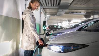 Jeune femme chargeant un véhicule électrique dans un garage souterrain