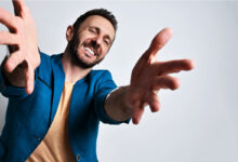 Un homme en chemise bleu qui tend les bras