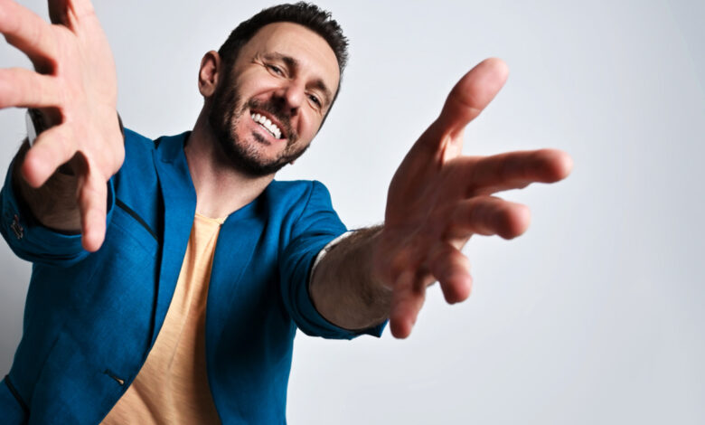 Un homme en chemise bleu qui tend les bras