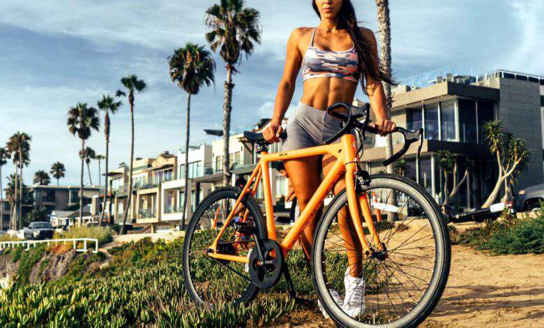 Une femme brune tenant le vélo électrique BABYMAKER PRO™