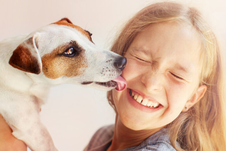 Un chien qui lèche le visage d'une jeune fille