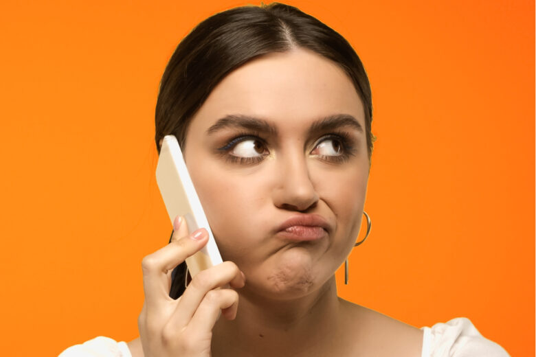 Une femme qui fait la grimace en parlant dans son téléphone