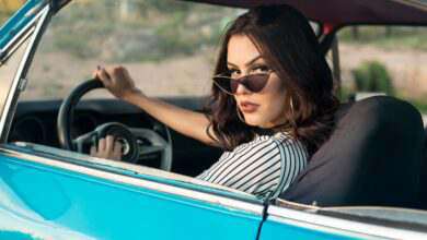 une femme avec des lunettes de soleil qui regarde par la fenêtre de sa voiture