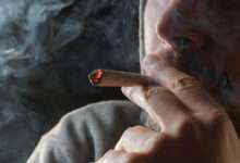 un homme qui fume un joint de cannabis