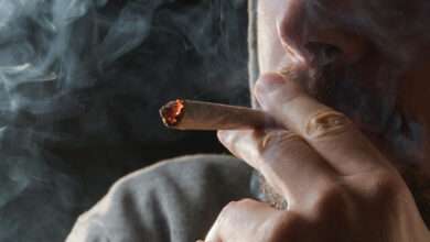 un homme qui fume un joint de cannabis