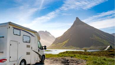 Un camping car devant un lac et une montagne