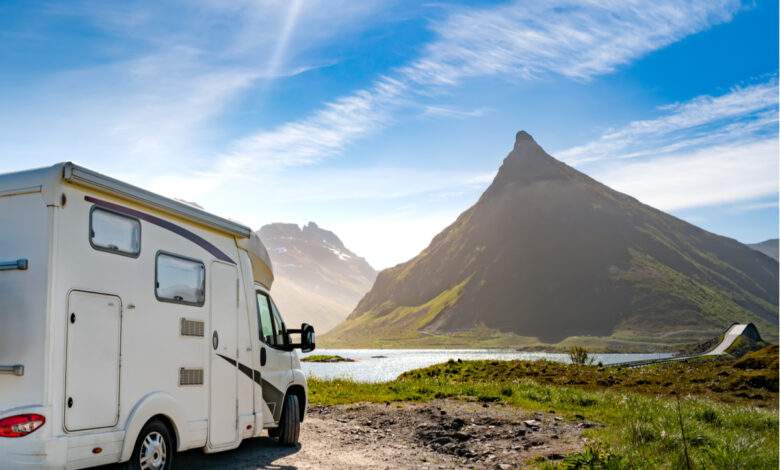 Un camping car devant un lac et une montagne