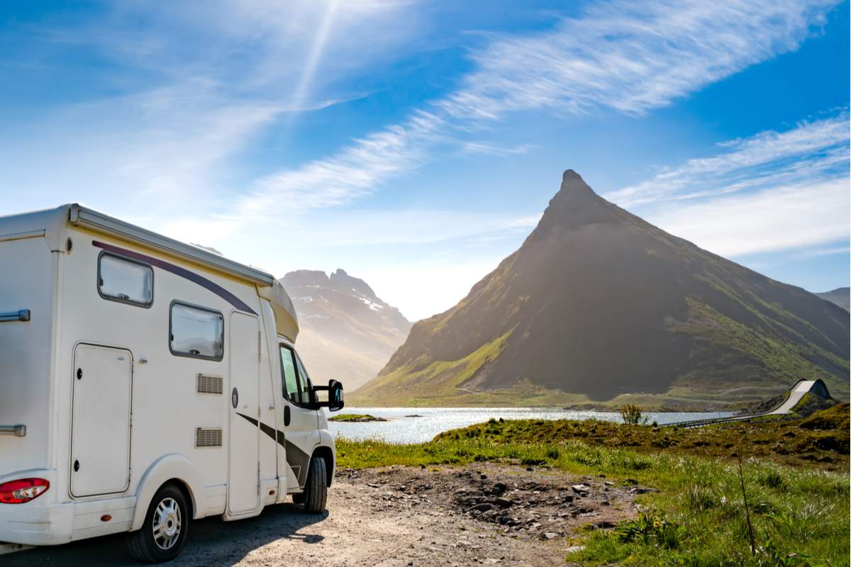 Un camping car devant un lac et une montagne