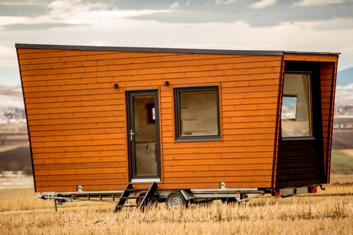 Une belle Tiny House en bois posée dans un champs