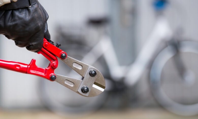 un homme avec une pince coupante va voler un vélo